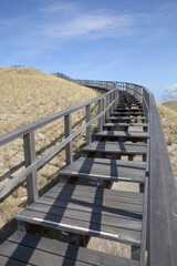 Fototapeta na wymiar A wooden stairway in the dunes of Petten, the Netherlands, leading to a viewing point 