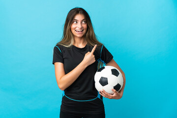 Young football player woman isolated on blue background pointing to the side to present a product