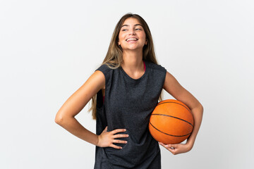 Young woman playing basketball isolated on white background posing with arms at hip and smiling