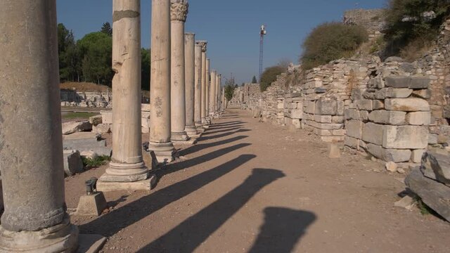 Ancient Roman columns along the road of ruined antique city.