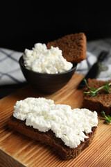 Bread with cottage cheese and microgreens on wooden board, closeup