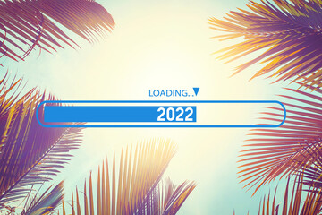 Palm tree with loading bar 2022 on sunset sky abstract background. Happy new year and travel...