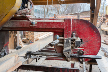 Sawing wood on old sawmill equipment outdoors. Woodworking industry