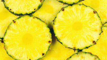 Pineapple juicy yellow slices background. Top view.