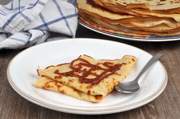 Crêpe avec du caramel au beurre salé servie dans une assiette avec une cuillère