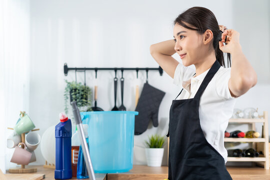 Asian Cleaning Service Woman Worker Tying Hair Before Doing Housework. 