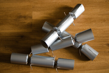 Pile of Christmas crackers on wooden background, top view