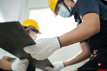 Asian builder worker people wear mask installs laminate board on floor