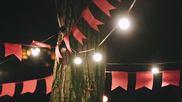 decoration in the form of red flags and glowing Christmas garlands hanging on the street