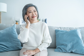 Asian senior elderly woman smile and video call in living room at home