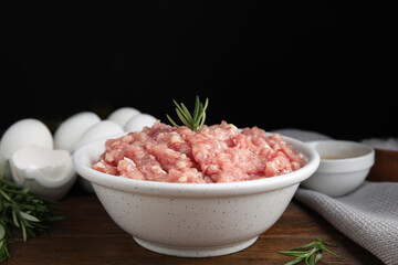 Fototapeta na wymiar Raw chicken minced meat with rosemary on wooden table