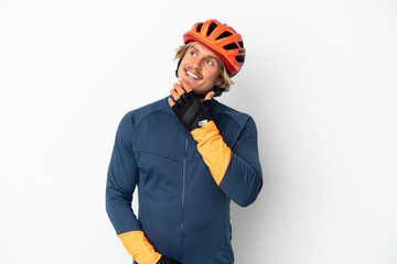 Young blonde cyclist man isolated on white background looking up while smiling