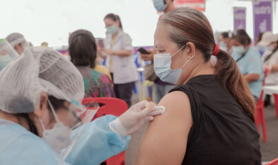 Fat Asia senior woman has gone to vaccinate coronavirus covid19 with medical staff in a field...