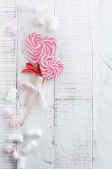 Group of festive various candies in form of heart on white wooden background. Selective focus. Vintage Valentine card. Top view. Place for text
