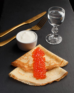 Golden russian pancakes with red caviar. Traditional Maslenitsa food. Christmas and New Year celebration.