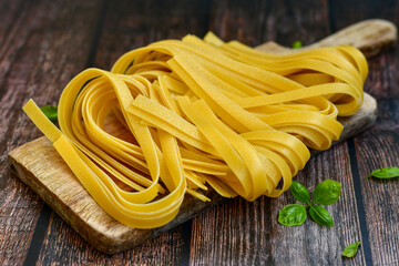 Raw fresh  uncooked tagliatelle egg pasta . Ready for cooking. Italian food concept. Kitchen poster