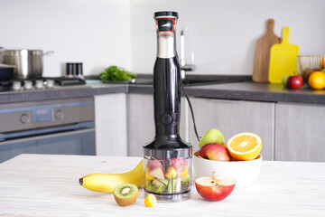 Hand blender for mixing organic raw fresh fruit for making vitamin diet smoothie, healthy food.