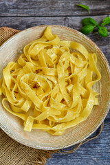 Italian food . Fresh home made  tagliatelle vegetarian  egg pasta  with ,parmesan cheese ,fresh parsley  and black pepper.Pasta cacio e pepe