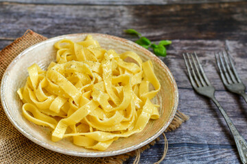 Italian food . Fresh home made  tagliatelle vegetarian  egg pasta  with ,parmesan cheese ,fresh parsley  and black pepper.Pasta cacio e pepe