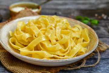 Italian food . Fresh home made  tagliatelle vegetarian  egg pasta  with ,parmesan cheese ,fresh parsley  and black pepper.Pasta cacio e pepe