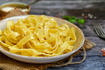Italian food . Fresh home made  tagliatelle vegetarian  egg pasta  with ,parmesan cheese ,fresh parsley  and black pepper.Pasta cacio e pepe