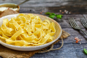 Italian food . Fresh home made  tagliatelle vegetarian  egg pasta  with ,parmesan cheese ,fresh parsley  and black pepper.Pasta cacio e pepe