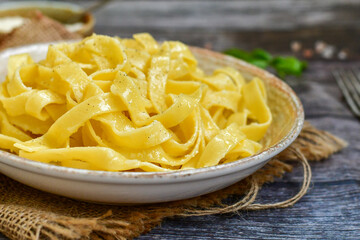 Italian food . Fresh home made  tagliatelle vegetarian  egg pasta  with ,parmesan cheese ,fresh parsley  and black pepper.Pasta cacio e pepe