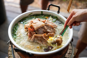Eating grilled pork with vegetable and soup in hot pan