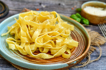 Italian food . Fresh home made  tagliatelle vegetarian  egg pasta  with ,parmesan cheese ,fresh parsley  and black pepper.Pasta cacio e pepe