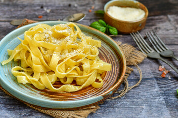 Italian food . Fresh home made  tagliatelle vegetarian  egg pasta  with ,parmesan cheese ,fresh parsley  and black pepper.Pasta cacio e pepe