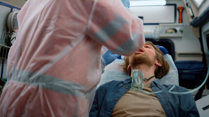 Emergency doctors taking nasophargeal swab of patient for coronavirus sample