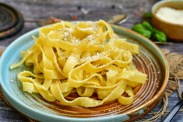 Italian food . Fresh home made  tagliatelle vegetarian  egg pasta  with ,parmesan cheese ,fresh parsley  and black pepper.Pasta cacio e pepe