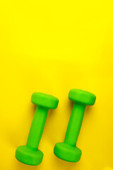 Two dumbbells, on a yellow background, health, diet, sports.