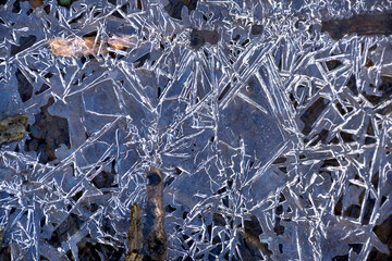 Texture of ice on frozen puddle in winter. Abstract blue winter background