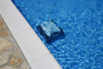 Cleaning the pool floor with an underwater vacuum cleaner, pool maintenance concept.