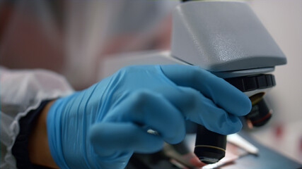 Scientist hand using microscope in laboratory. Researcher working with samples 