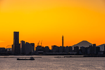 夕日に染まる横浜港と富士山のシルエット