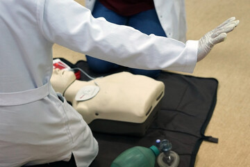 Basic life support simulation scenario for medical students on a dummy with an automatic external defibrillator during cardiopulmonary resuscitation.
