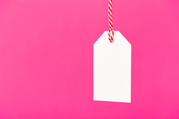 Blank white price tag isolated on pink background. Black friday, sale, discount concept.