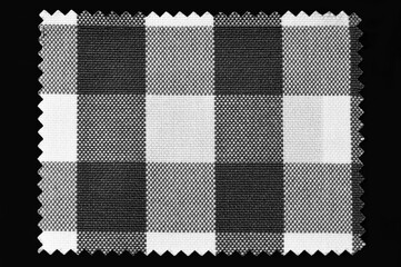 Black and white checkered fabric sample isolated on black background