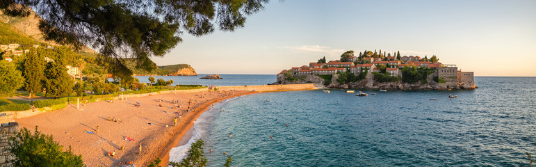 Panorama of a beach and Sveti Stefan island at sunset in Montenegro