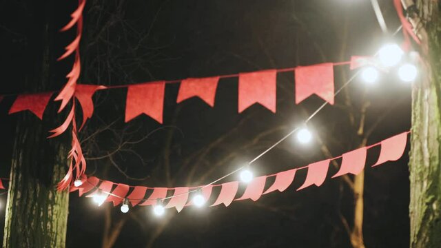 decoration in the form of red flags and glowing Christmas garlands hanging on the street