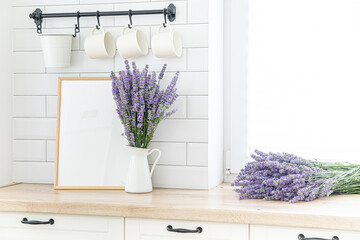 A bouquet of lavender in the interior of a stylish kitchen. Vertical frame mockup on a wooden table.