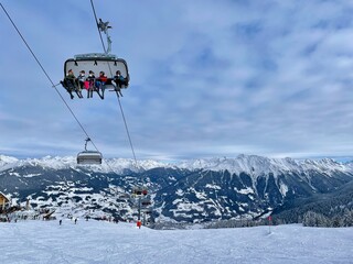 Skiers wearing facial mask during Corona pandemic on chairlift in winter ski resort Golm, Austria....