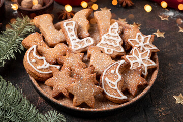  Festive Christmas cookies decorated with icing and powdered sugar on a plate close up