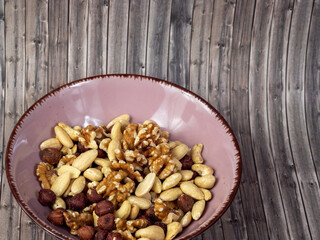 Mix nuts on a wooden background.