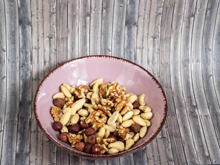 Mix nuts on a wooden background.