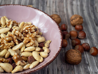 Mix nuts on a wooden background.