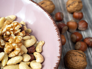Mix nuts on a wooden background.