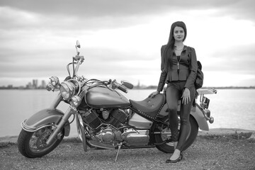 Fototapeta na wymiar young woman on a black motorcycle